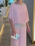 Woman wearing a 2-piece wide leg trouser set with a flowy blouse, perfect for all-season elegance.