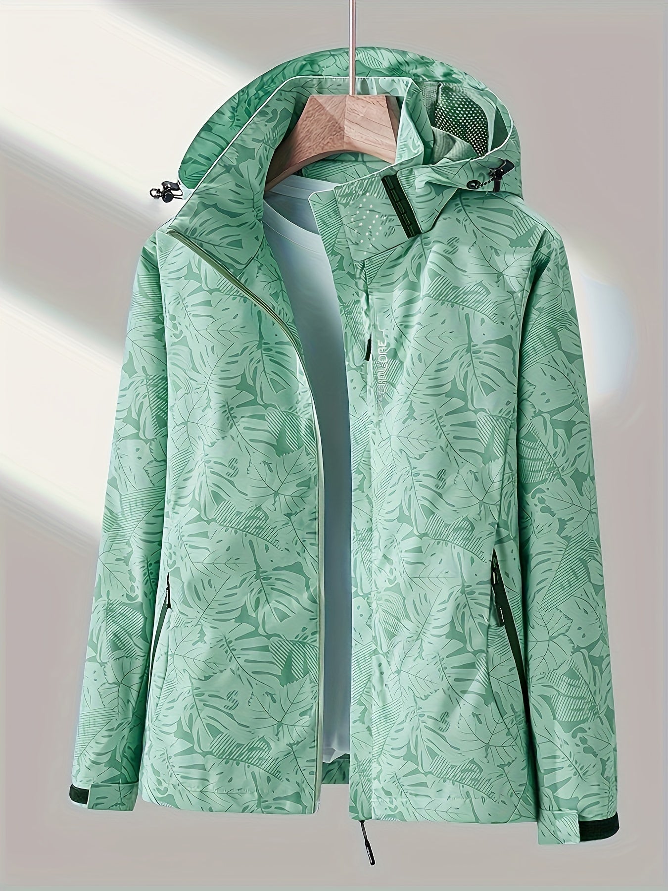 Women's camouflage jacket for outdoor activities, featuring a removable hood and waterproof design.