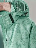Women's camouflage jacket with a removable hood for hiking and outdoor activities.