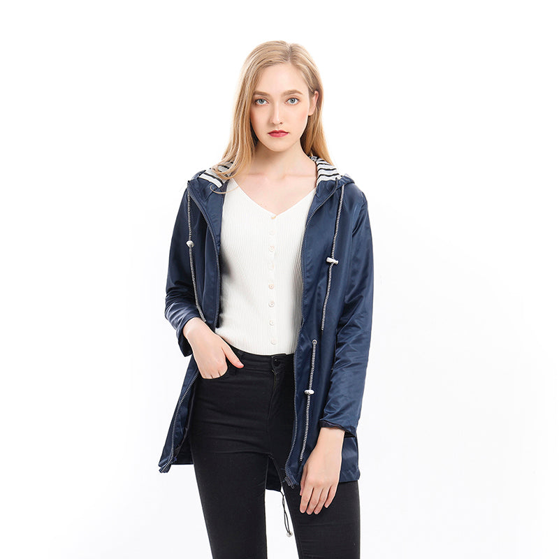 Woman wearing the all-season waterproof rain jacket in an outdoor setting, showcasing its lightweight and breathable design.