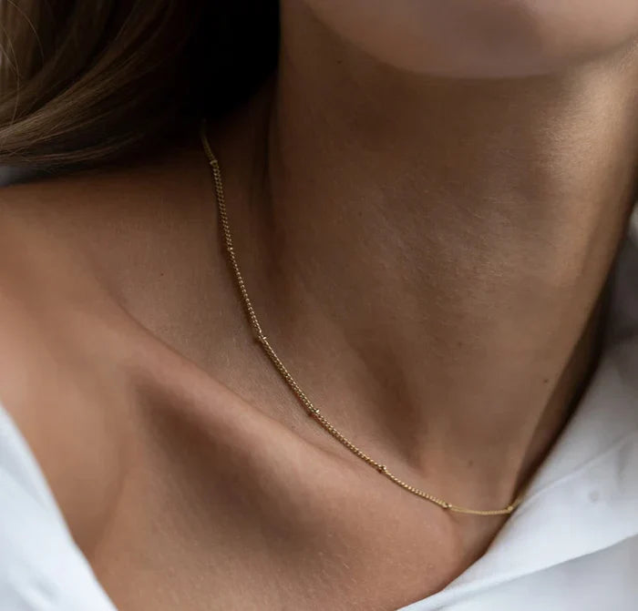 Woman wearing an ancient choker necklace, showcasing its intricate details and vintage-inspired design.